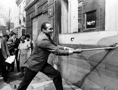Mayor Carl Stokes takes a crowbar to a building slated for demolition in 1969 on East 81st St. Courtesy of Cleveland Memory Project.