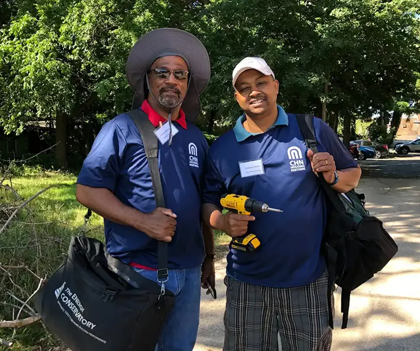 two men with tools and a bag