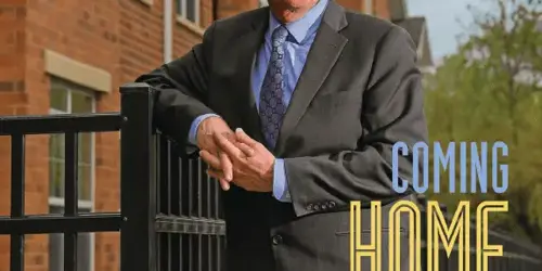 man standing in front of fence