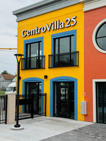 Yellow building with blue windows and building sign that reads CentroVilla 25.